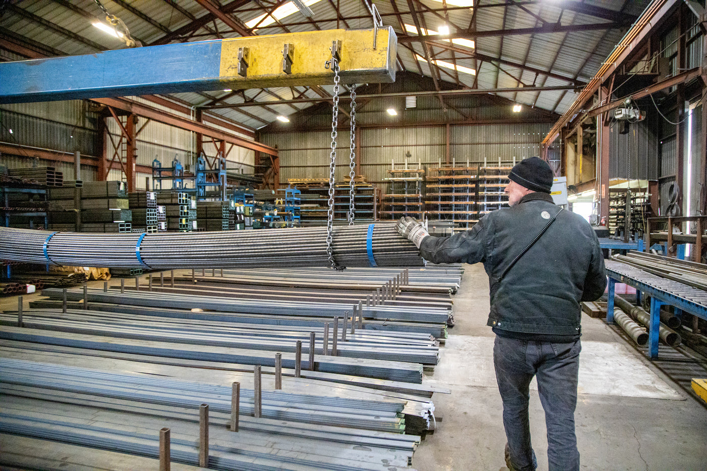 Crane moving a Steel bundle. Steel and Metals Warehouse with Steel, Aluminum, Stainless, Galvanized in all shapes and sizes, including: ar stock, plate, beam, pipe, tube, sheet, square, round, channel, beam, tube and more!